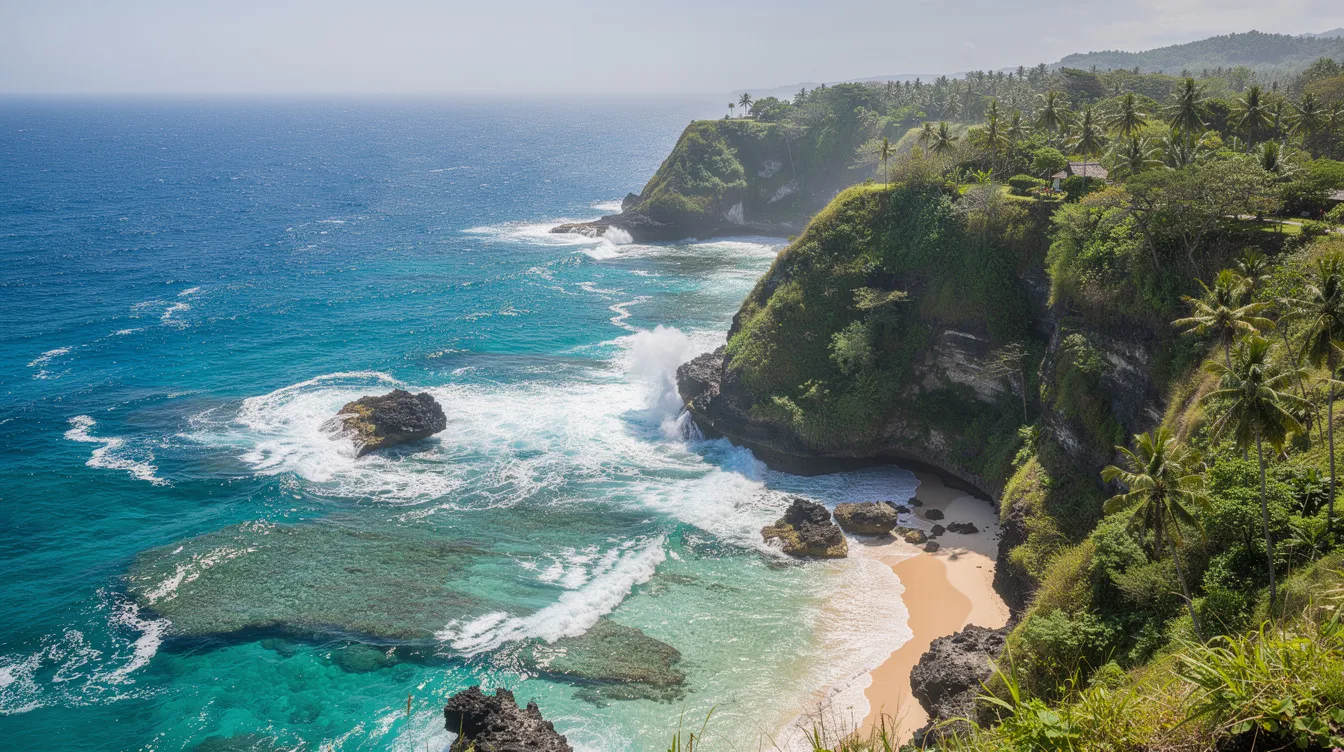 The image depicts a stunning tropical coastline in Bali, where turquoise waves crash against dramatic green cliffs under a clear blue sky, showcasing the island's natural beauty. This picturesque scene highlights Bali's allure as a travel destination, perfect for beach lovers and outdoor activities.